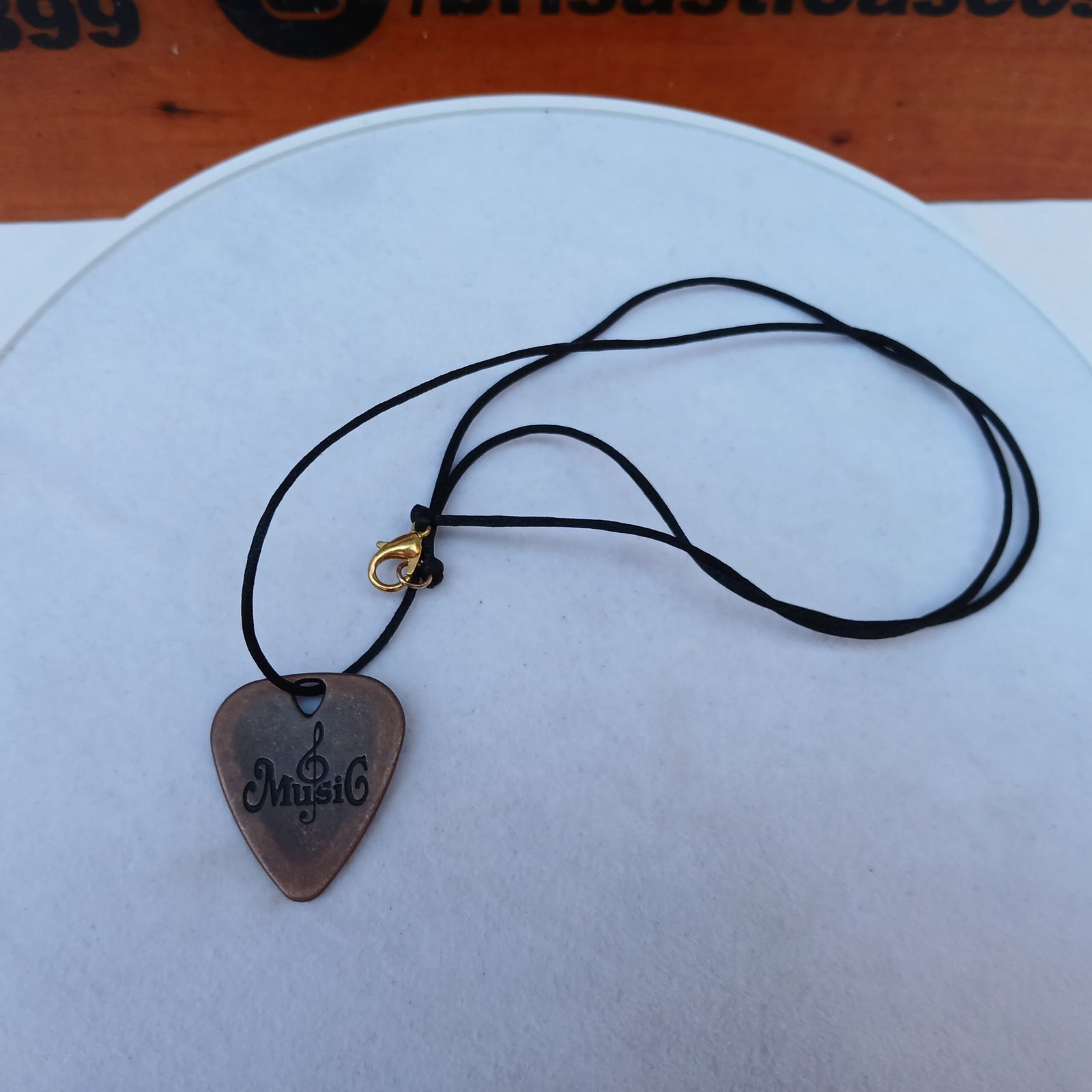 Cadena con dije púa de guitarra color cobre vintage, cordón negro